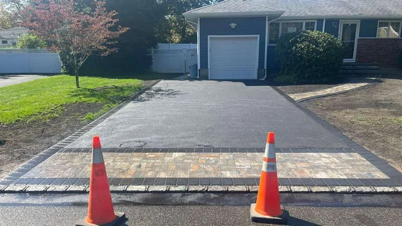 Fresh blacktop finished with a paver apron and border.