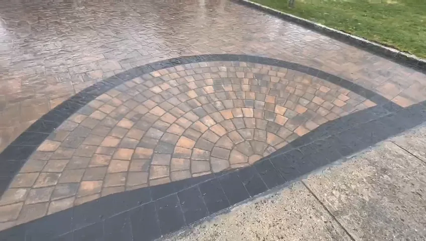Curved paver apron with a brick medallion where the driveway meets the street.